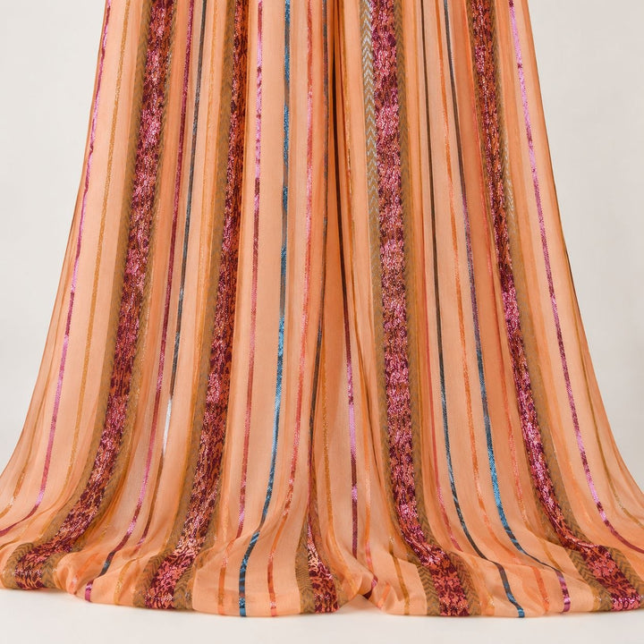 Persikoorange lurex chiffonsilk med flerfärgade glittrande ränder – hängande i mjuka veck på vit bakgrund (bild 2 av 3)