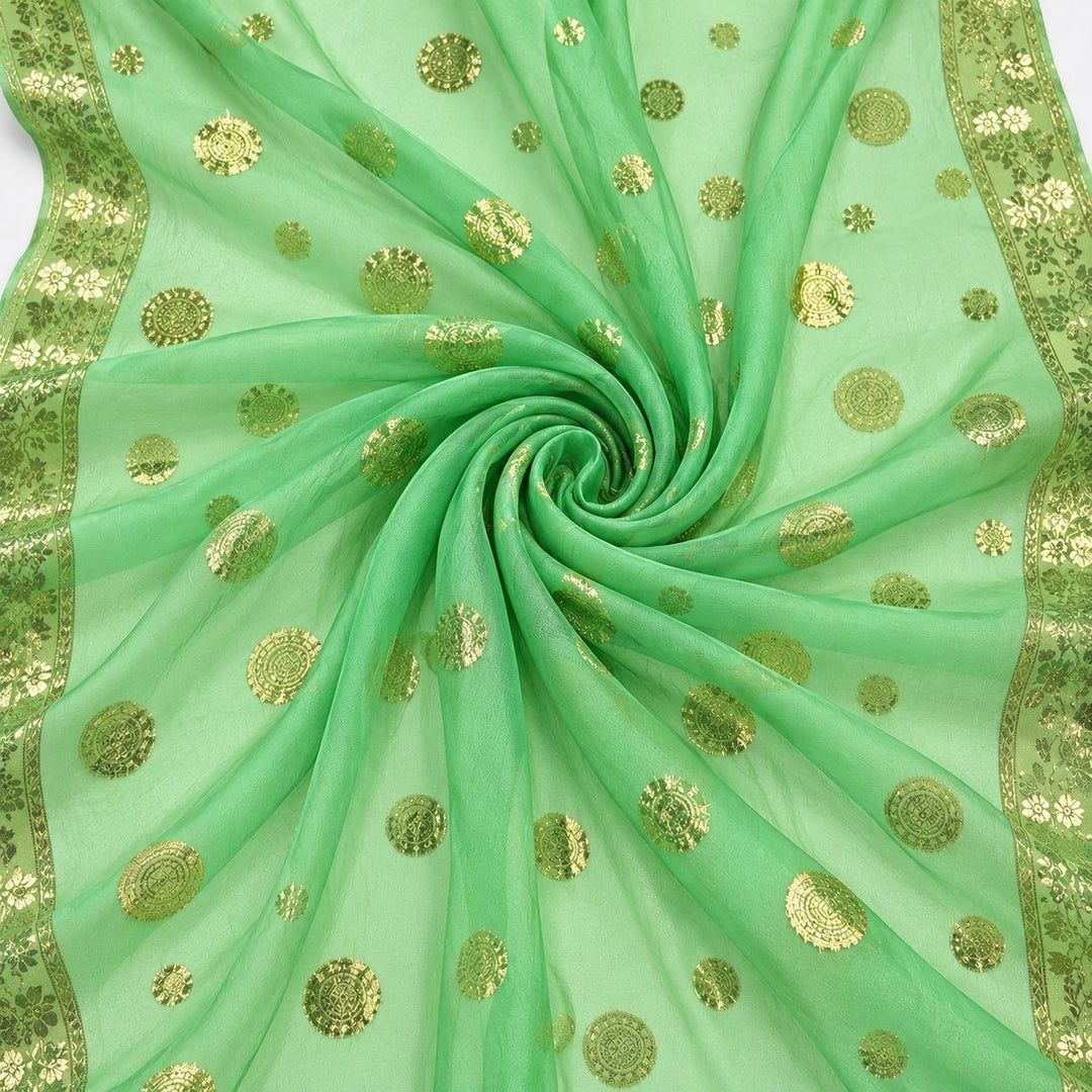 Mintgrön lurex chiffonsilk med gyllene prickmotiv och guldborter – tyget format som en spiral (bild 1 av 3)