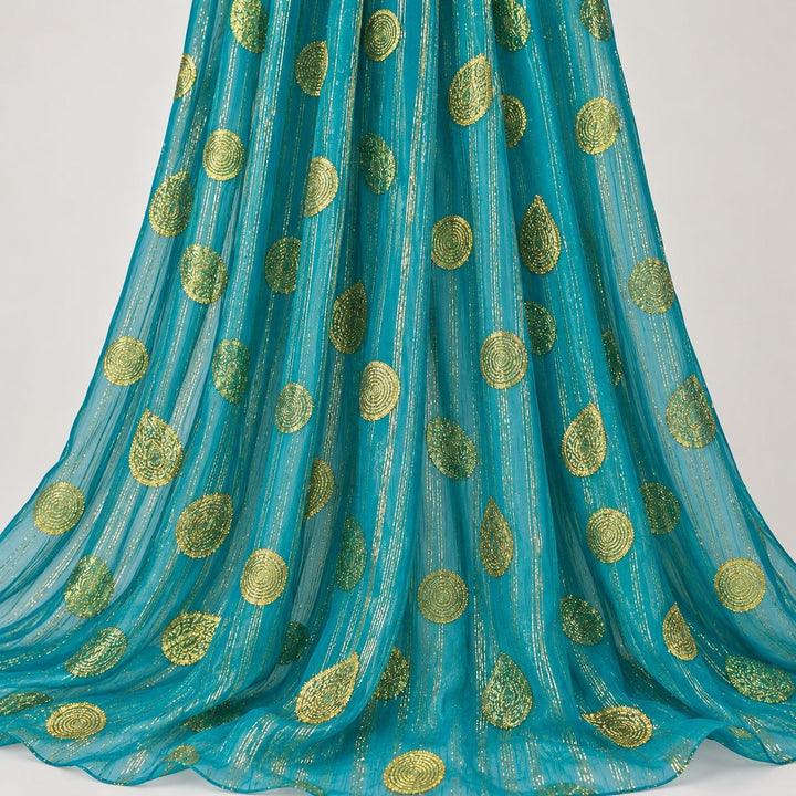 Turkos lurex chiffonsilk med gyllene ränder och motiv – hängande i mjuka veck på vit bakgrund (bild 2 av 3)