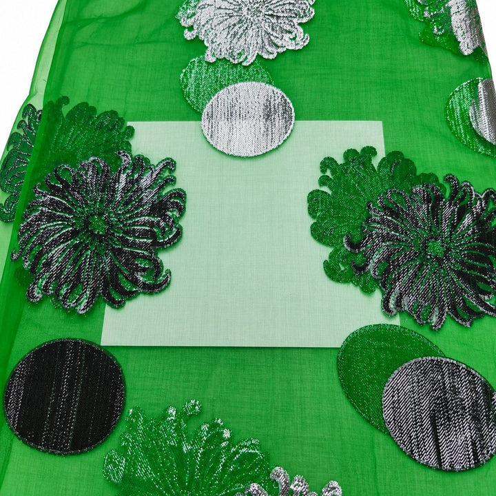 Smaragdgrön lurex chiffonsilk – närbild på blom- och cirkelmotiven och tygets genomskinlighet (bild 3 av 3)