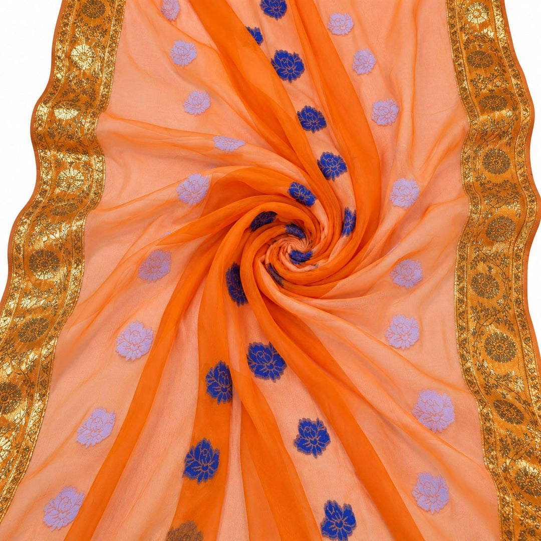 Orange lurex chiffonsilk med blå och ljuslila blommotiv och guldborter – tyget format som en spiral (bild 1 av 3)