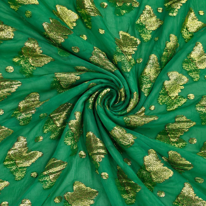 Smaragdgrön lurex chiffonsilk med gyllene fjärilsmotiv och prickar – tyget format som en spiral (bild 1 av 3)