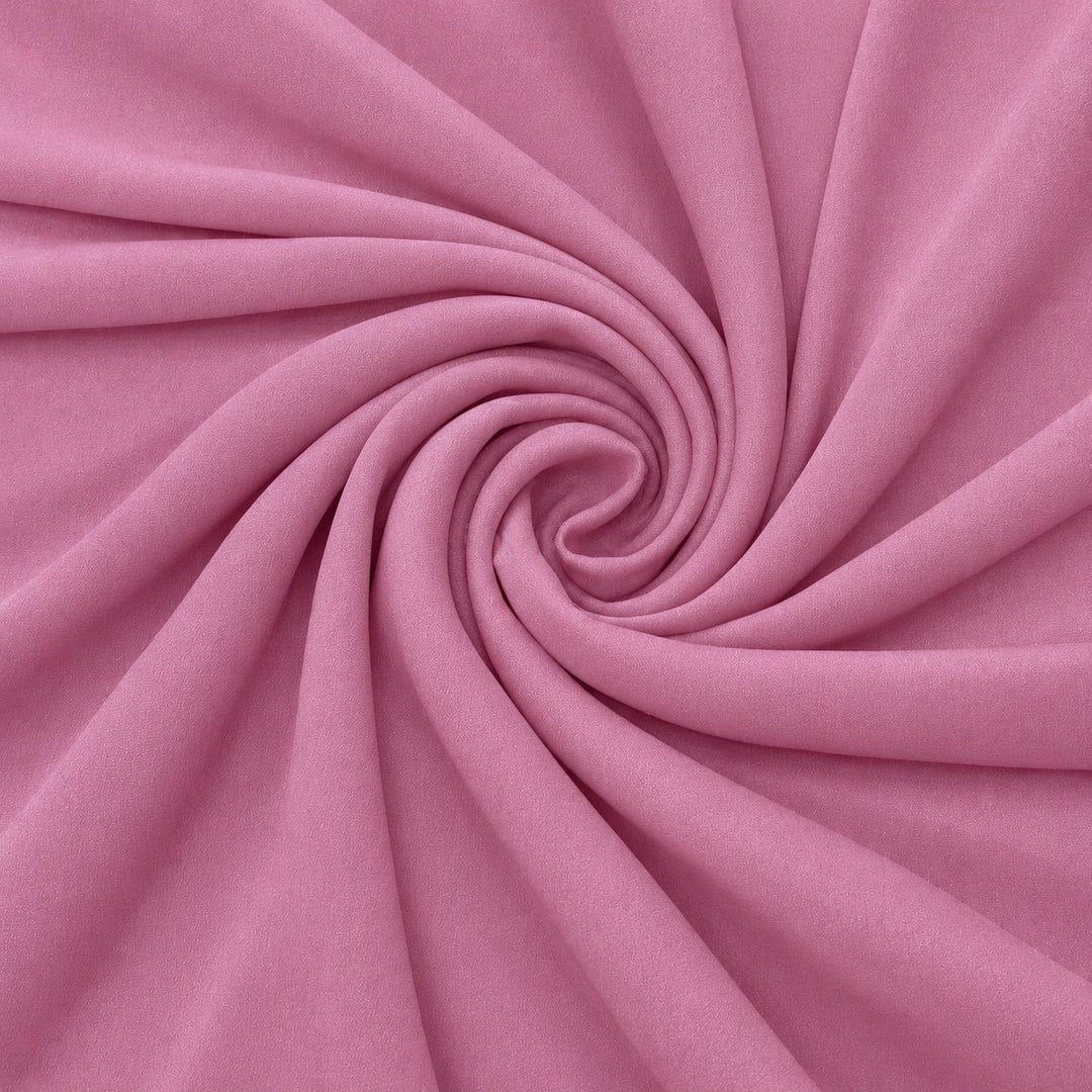 Dammigt rosa sidengeorgette – tyget format som en spiral, där den creppade ytan syns (bild 1 av 3)