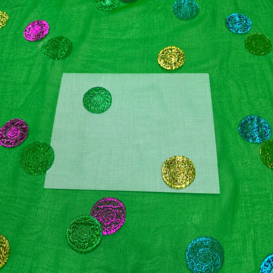 Grön lurex chiffonsilk – närbild på de flerfärgade prickarna och tygets genomskinlighet (bild 3 av 3)