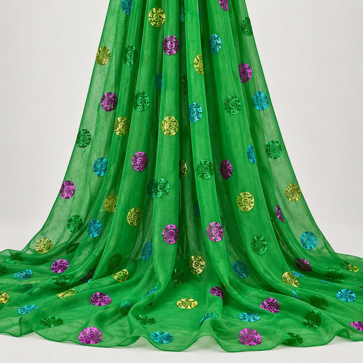 Grön lurex chiffonsilk med flerfärgade glittrande prickar – hängande i mjuka veck på vit bakgrund (bild 2 av 3)
